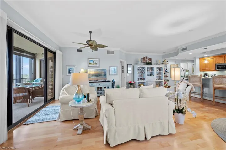 Living area with ornamental molding, a ceiling fan, light wood-style flooring, and recessed lighting