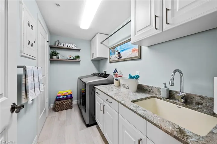 Laundry area with washing machine and dryer, cabinet space, and electric panel