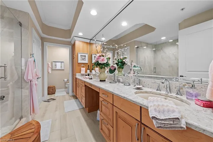 Bathroom with a shower stall, vanity, and recessed lighting