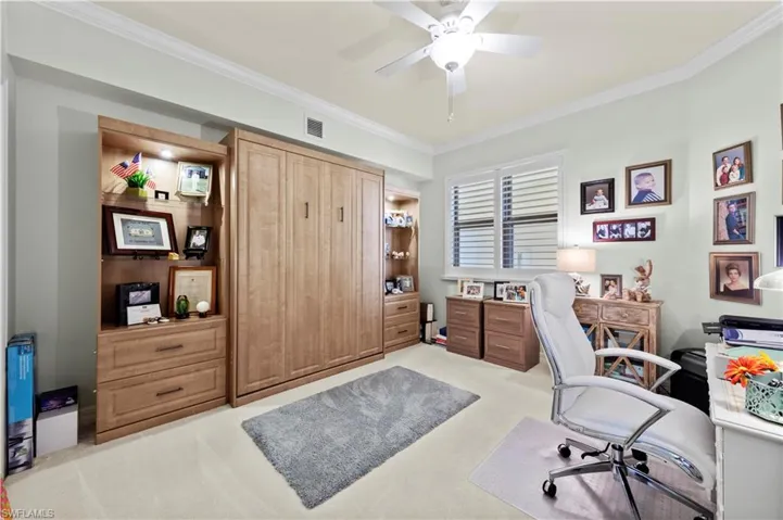 Office space featuring light colored carpet, a ceiling fan, and ornamental molding