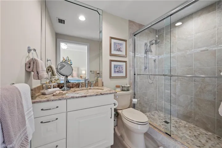 Bathroom featuring a stall shower, vanity, and recessed lighting