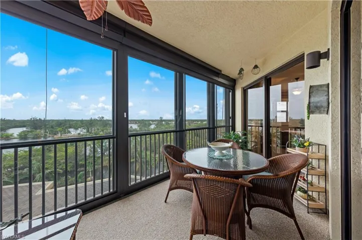 Sunroom featuring a textured ceiling, a water view, and carpet floors