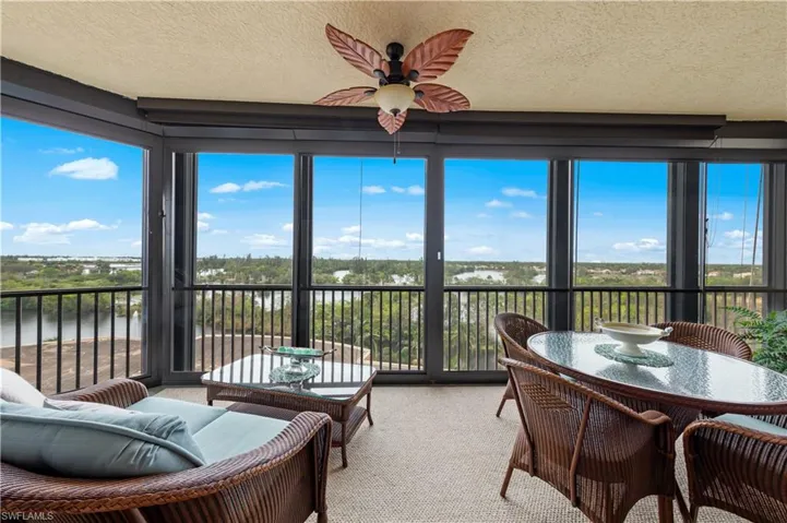 Sunroom / solarium with a water view, carpet, and a textured ceiling