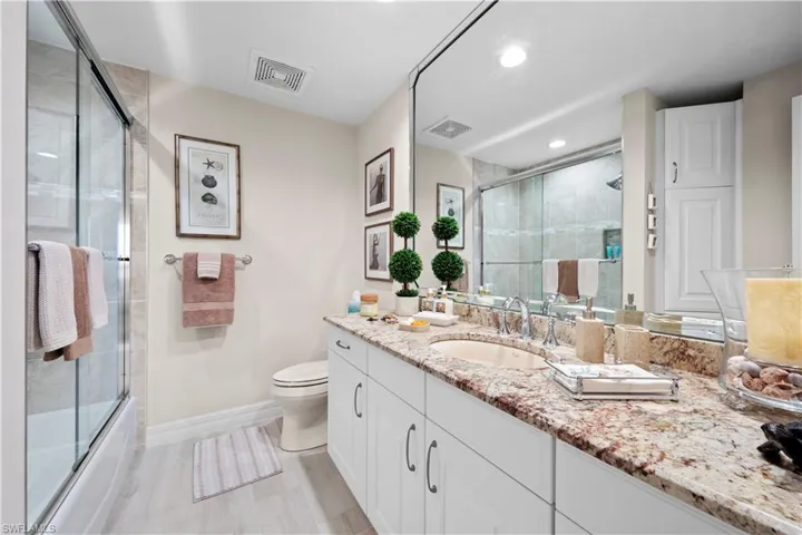 Bathroom with vanity, enclosed tub / shower combo, and recessed lighting