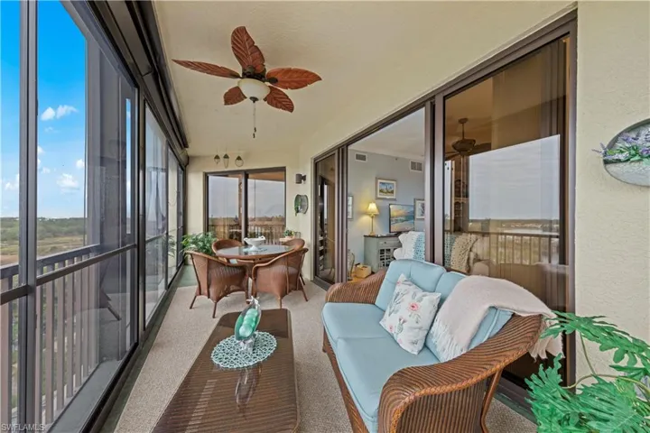 Sunroom with a ceiling fan, carpet, and an outdoor hangout area