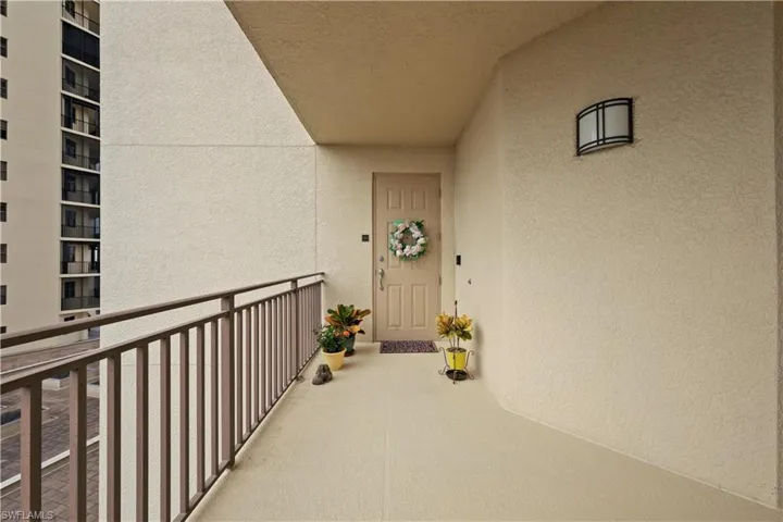 View of exterior entry with stucco siding and a balcony