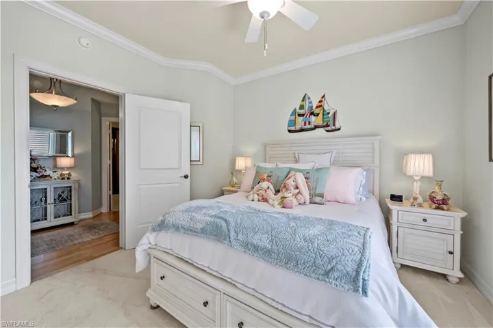 Bedroom featuring ornamental molding, light carpet, and a ceiling fan