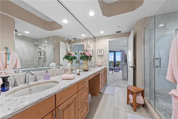 Bathroom featuring a stall shower, vanity, and recessed lighting