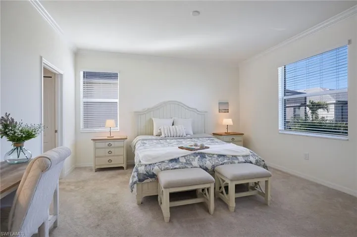 Owners suite bedroom featuring crown molding