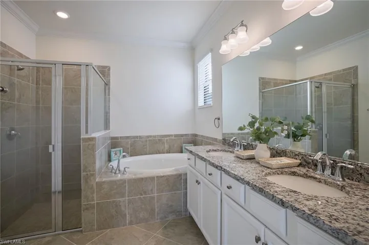 Bathroom featuring crown molding, separate shower and tub, tile patterned floors, and vanity