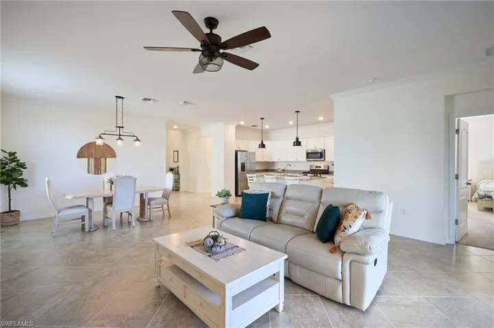 Living room featuring ornamental molding, sink, and ceiling fan