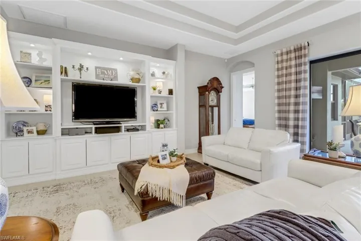 Living area featuring built in shelves and arched walkways