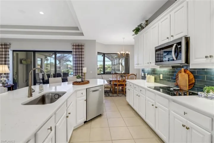 Kitchen featuring light tile patterned floors, appliances with stainless steel finishes, a chandelier, and light countertops