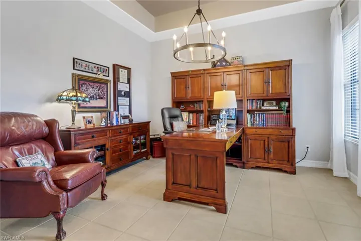 Office featuring a chandelier, light tile patterned floors, and a high ceiling