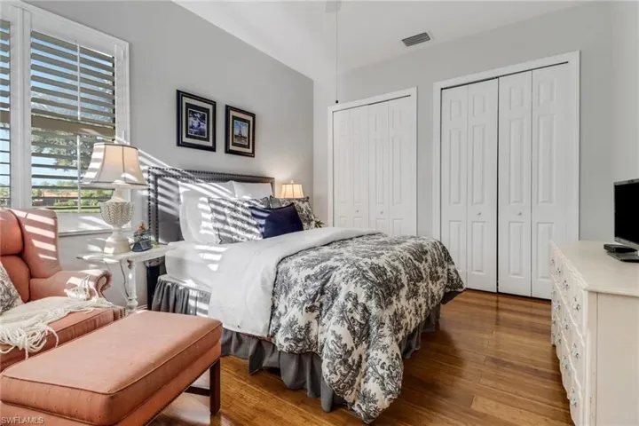 Bedroom with multiple closets and wood finished floors