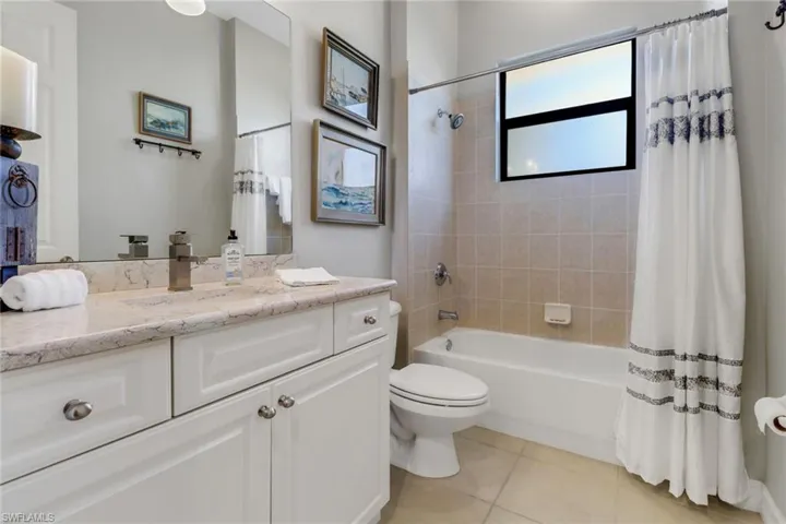 Full bath featuring vanity, shower / bath combo, and tile patterned floors