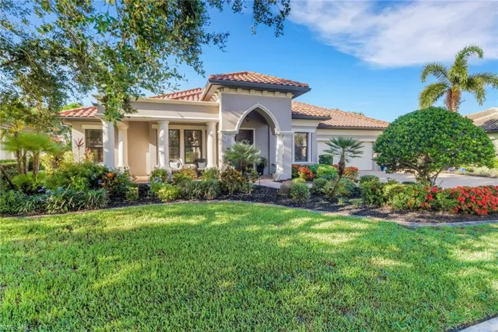 Mediterranean / spanish home with a garage, a front yard, stucco siding, and a tile roof
