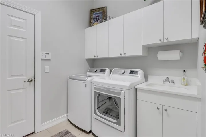 Laundry room featuring separate washer and dryer and cabinet space