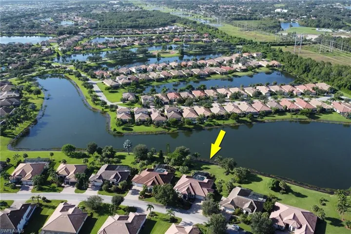 Aerial view of property and surrounding area featuring nearby suburban area and a large body of water