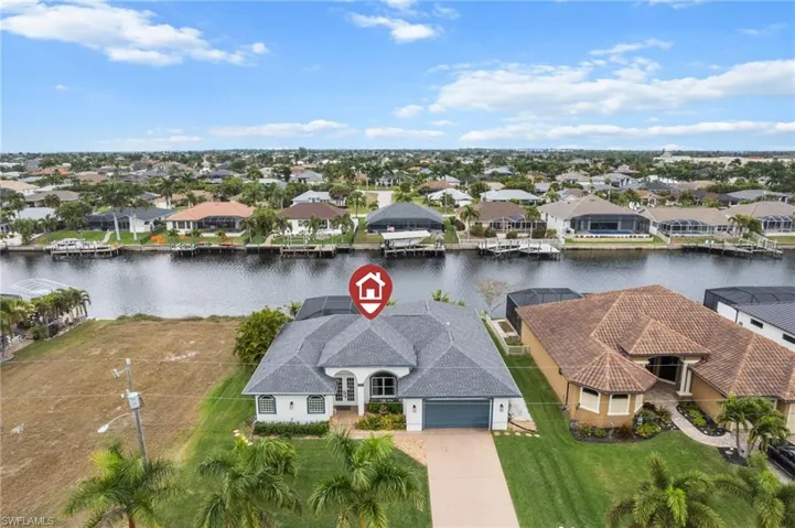 Aerial perspective of suburban area featuring a nearby body of water