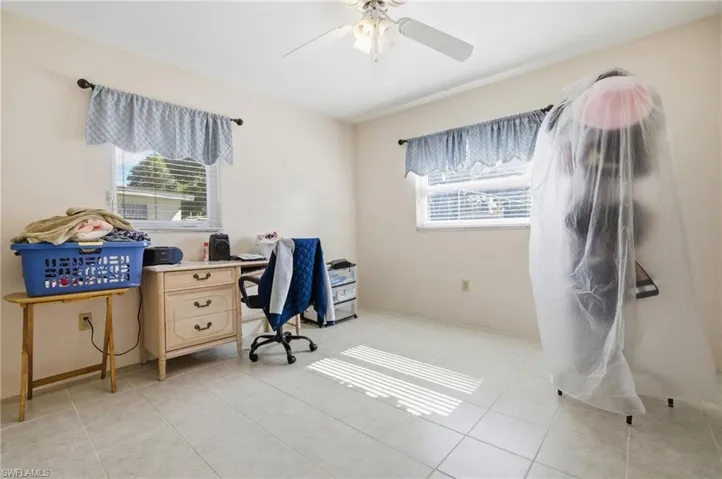 Home office with light tile patterned flooring and ceiling fan