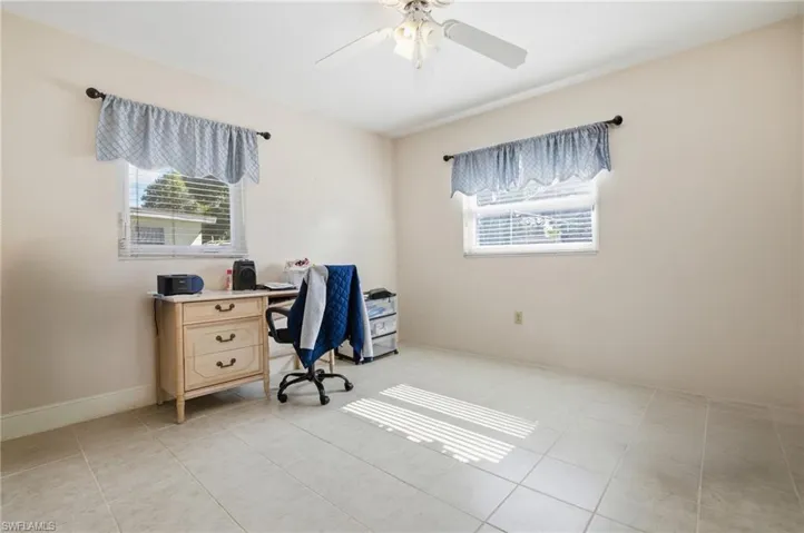 Office area featuring light tile patterned floors and a ceiling fan