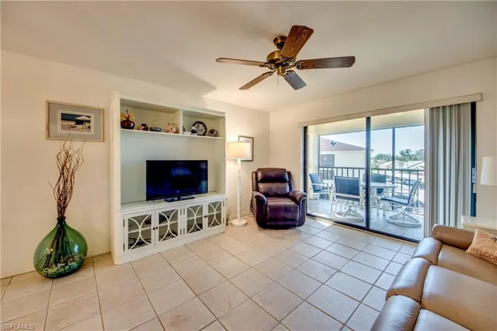Living room with ceiling fan and light tile patterned floors