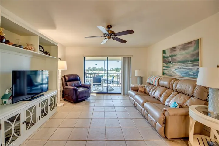 Living room with light tile patterned flooring and ceiling fan