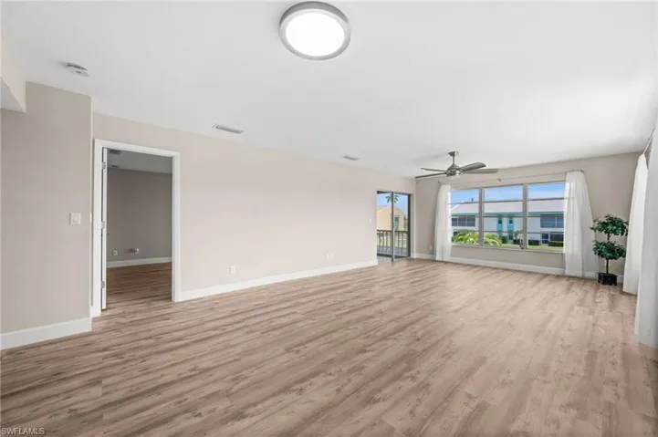 Living Room with door to the Primary Suite to the left, and access to the lanai