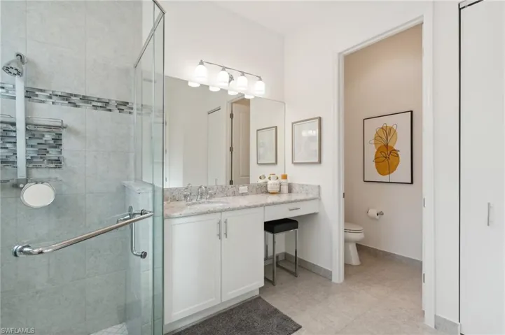 Bathroom featuring vanity, toilet, and walk in shower