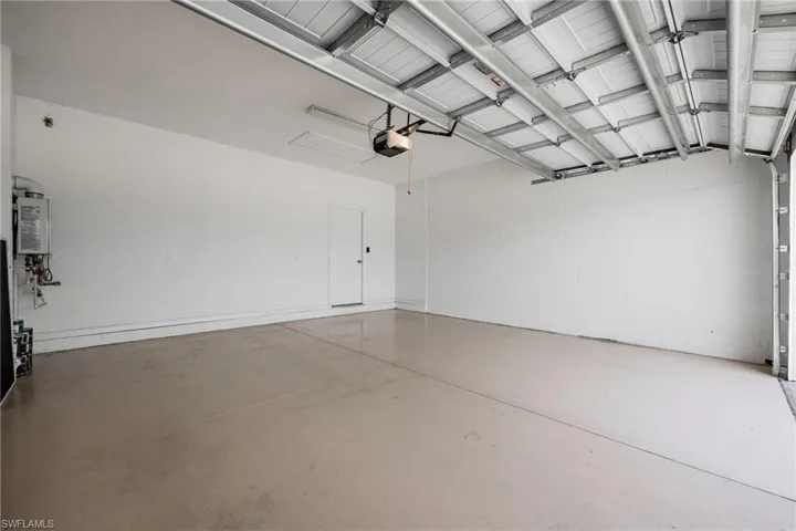 Garage featuring a garage door opener and water heater