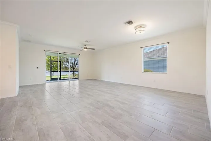 Spare room with crown molding, ceiling fan, and baseboards