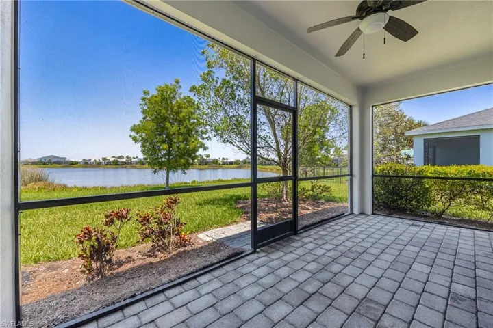 Unfurnished sunroom featuring a water view and a ceiling fan