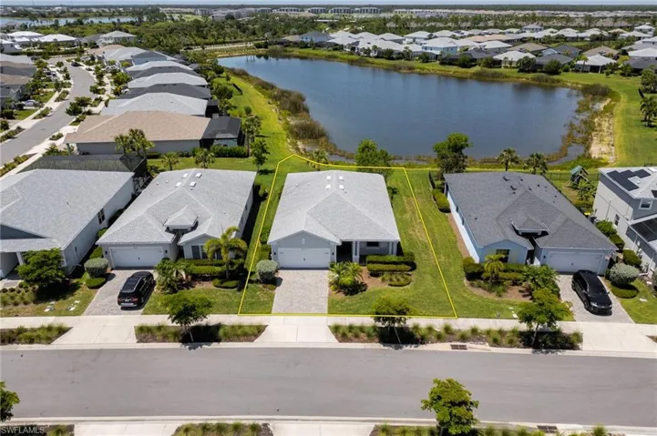 Aerial perspective of suburban area with property boundaries highlighted and a nearby body of water