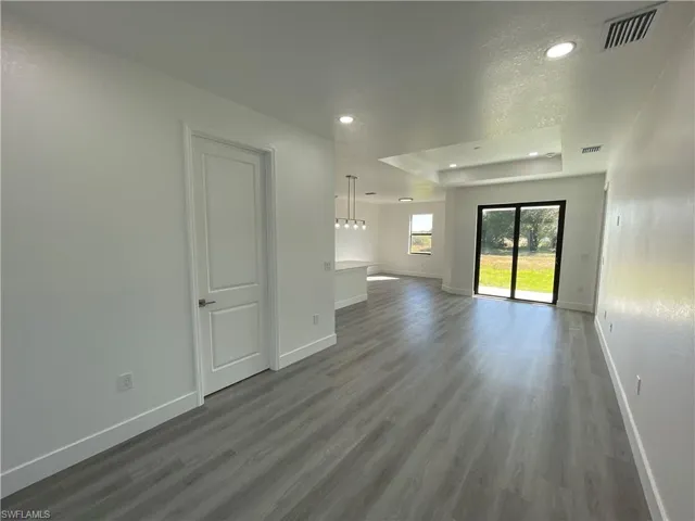 Unfurnished living room featuring wood-type flooring and a textured ceiling