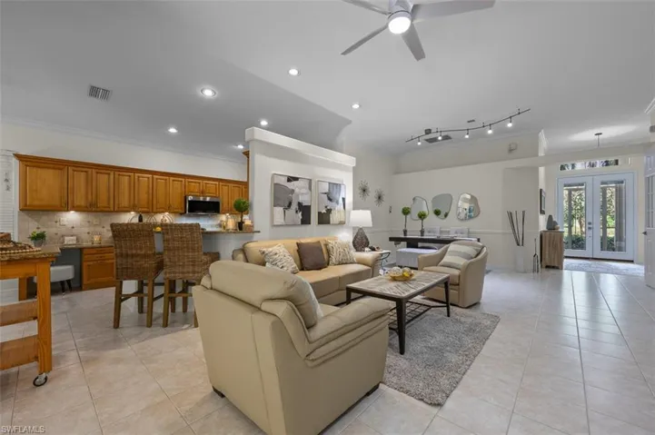 Tiled living room featuring track lighting, french doors, ornamental molding, and ceiling fan