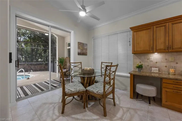 Tiled dining space featuring ceiling fan and vaulted ceiling