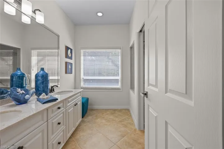 Bathroom featuring tile patterned flooring, dual bowl vanity, and plenty of natural light