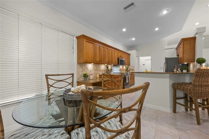 Tiled dining room featuring vaulted ceiling
