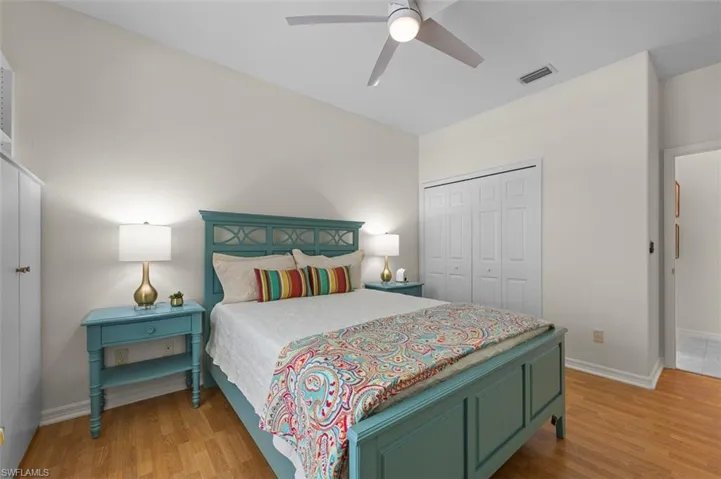Bedroom with ceiling fan, a closet, and light hardwood / wood-style floors
