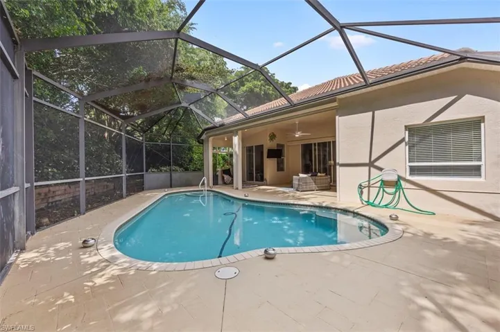 View of swimming pool featuring a patio area, a lanai, and ceiling fan