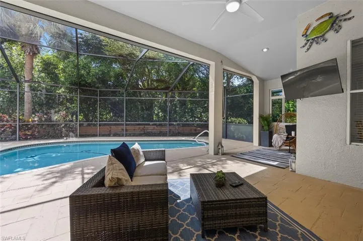 View of swimming pool with a patio area, a lanai, and ceiling fan