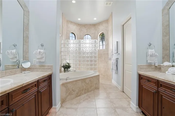 Bathroom with a garden tub, vanity, and walk in shower