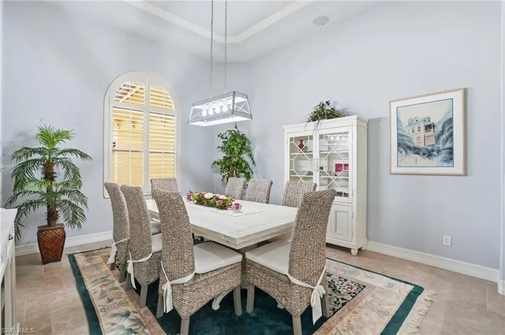Dining space featuring a raised ceiling and crown molding
