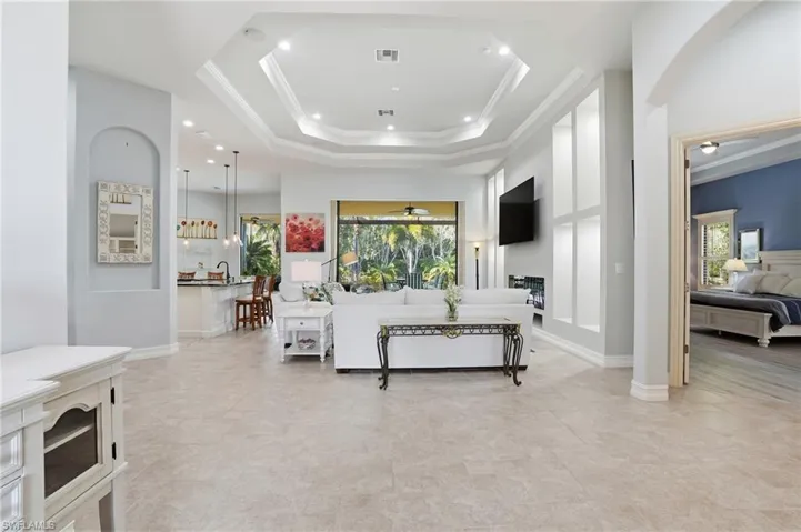 Living room featuring ornamental molding, recessed lighting, and a tray ceiling