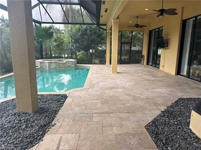 Integrated pool / hot tub featuring a patio, glass enclosure, and a sunroom