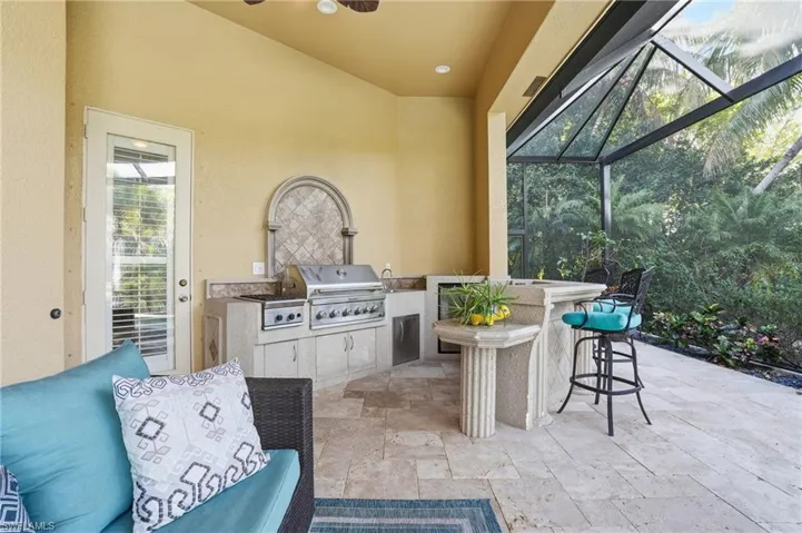 View of patio / terrace with exterior kitchen, a lanai, a sunroom, and a ceiling fan