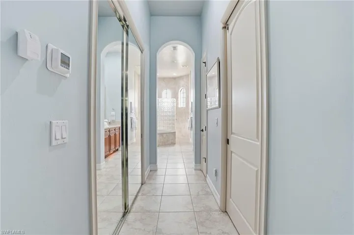 Hall with arched walkways and light tile patterned floors