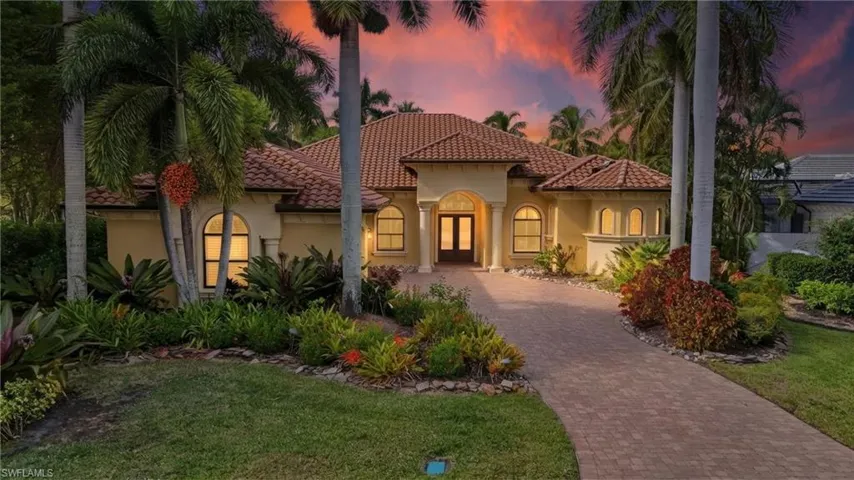 Mediterranean / spanish-style house with stucco siding, decorative driveway, a tiled roof, and a lawn