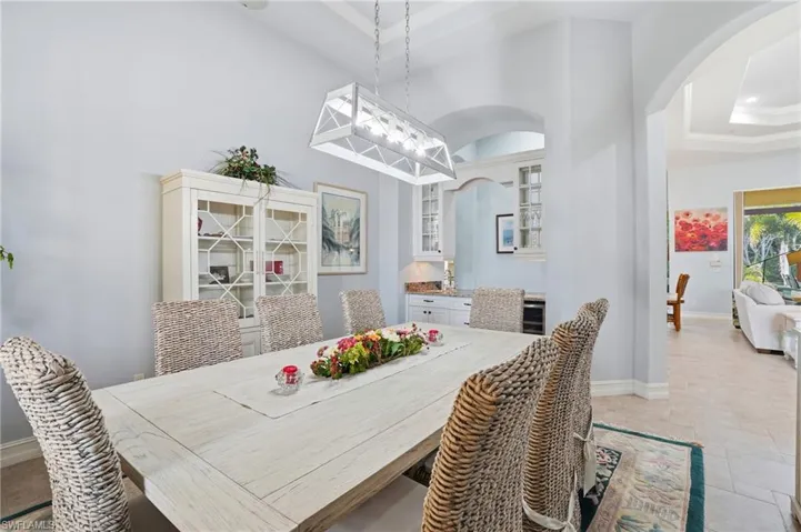 Dining room featuring a raised ceiling and arched walkways